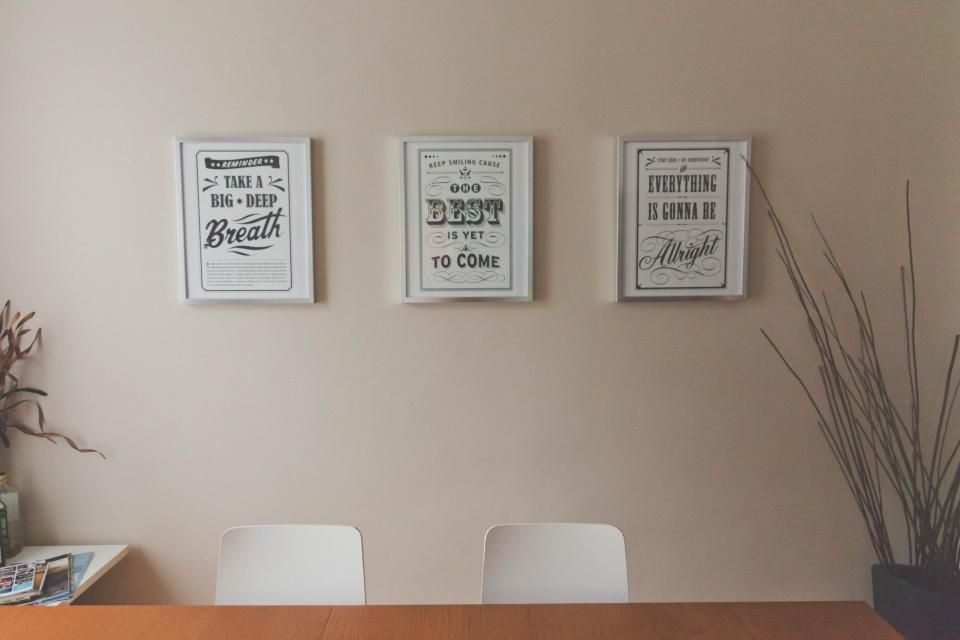 Framed artwork mounted above an office table