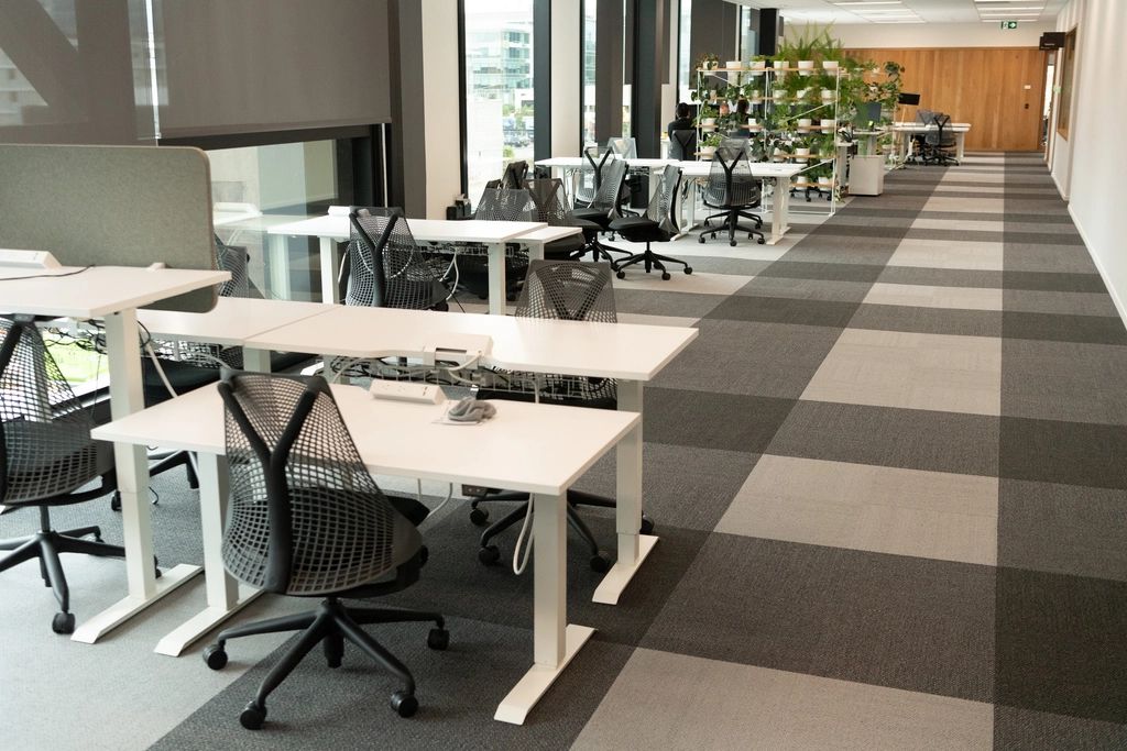 Open office with rows of white desks and task chairs