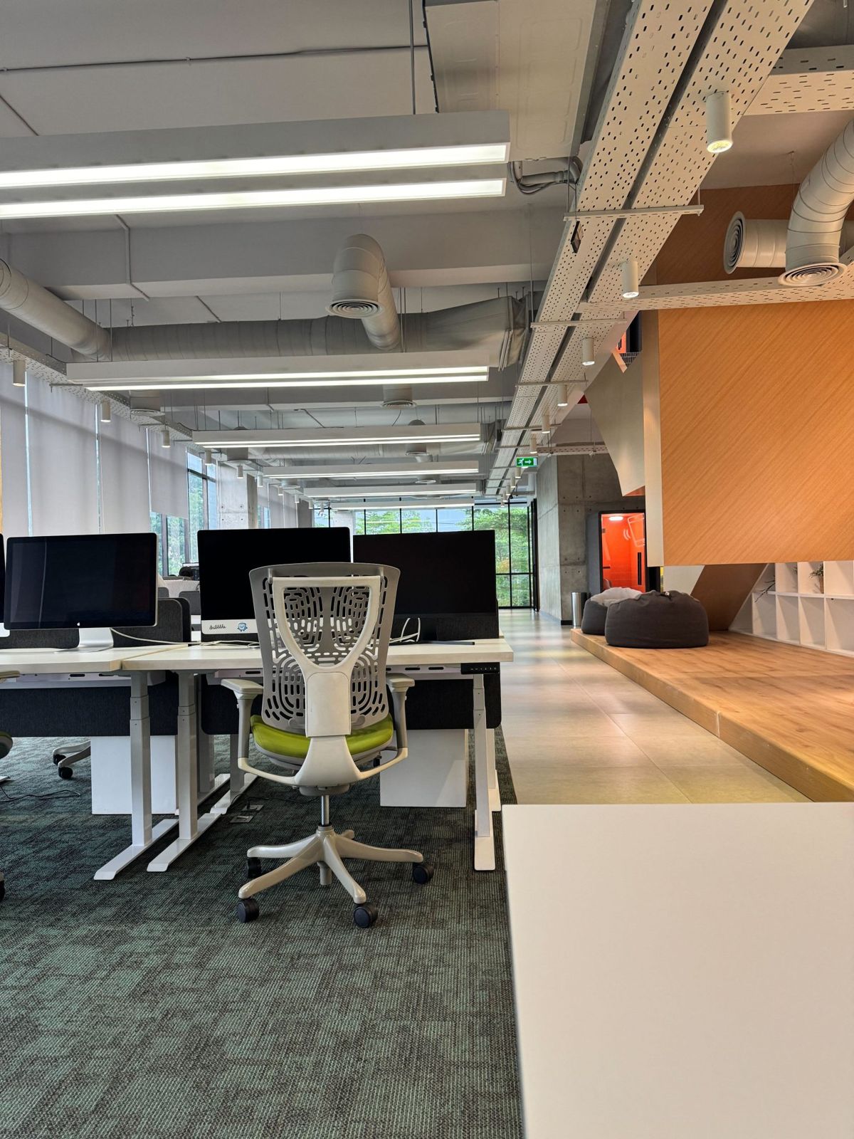 Open office workstations with monitors and ergonomic chairs